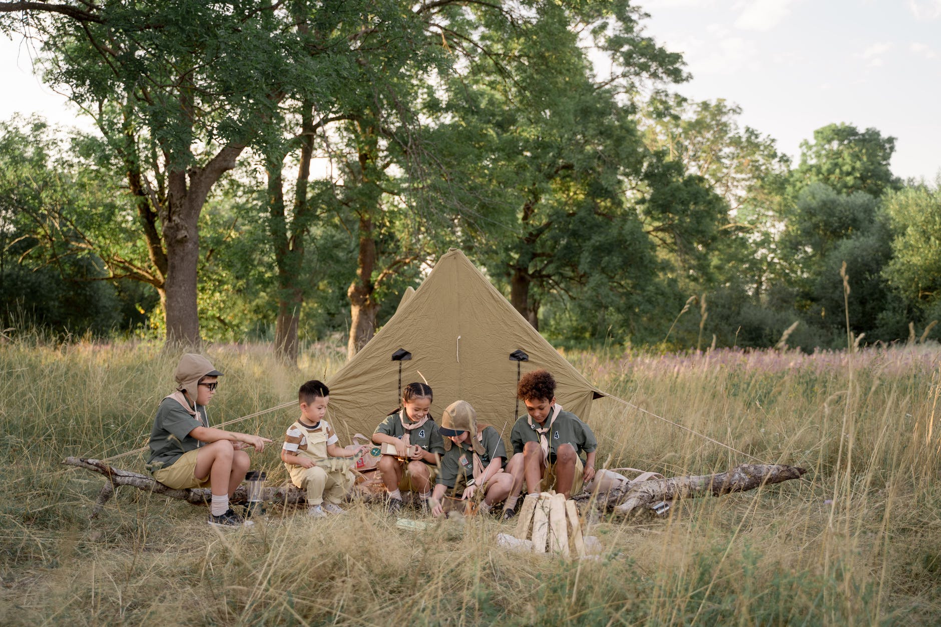 multiracial children sitting beside tent